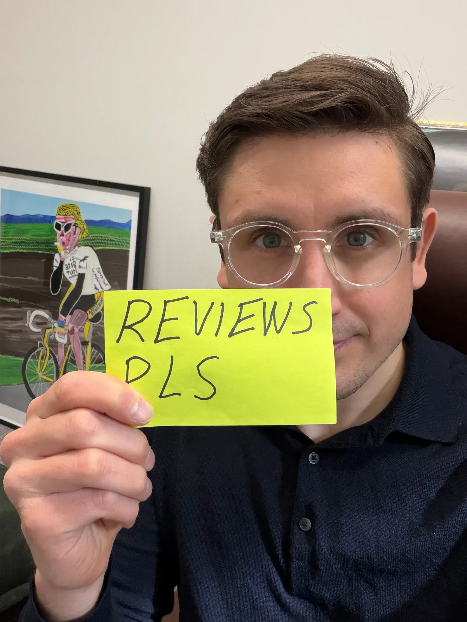 Karri holding up a sticky note that reads “Reviews pls”