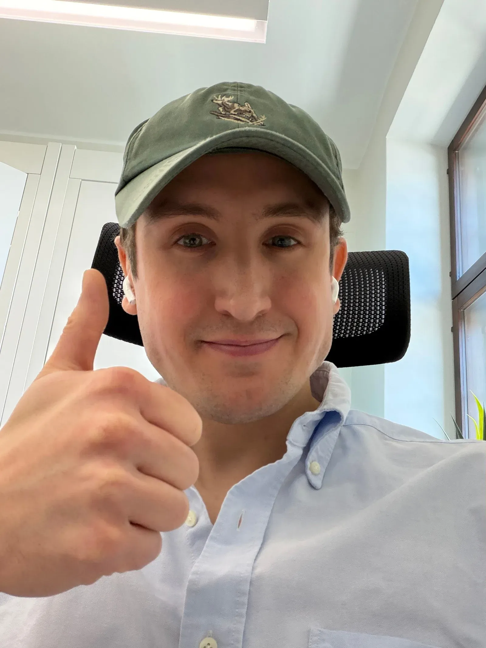 Karri in a cap, giving a thumbs up