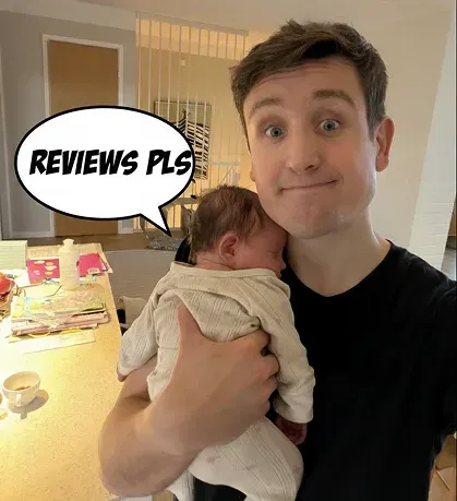 Karri holding his baby, with a comic speech bubble reading “Reviews pls”