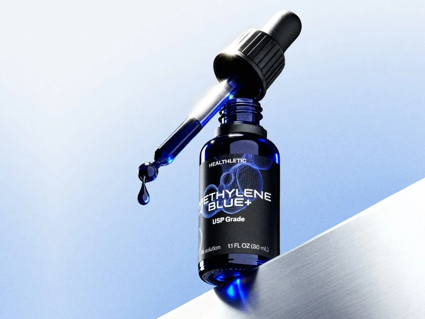 A dropper bottle of Healthletic Methylene Blue+ standing on a brushed metal ledge