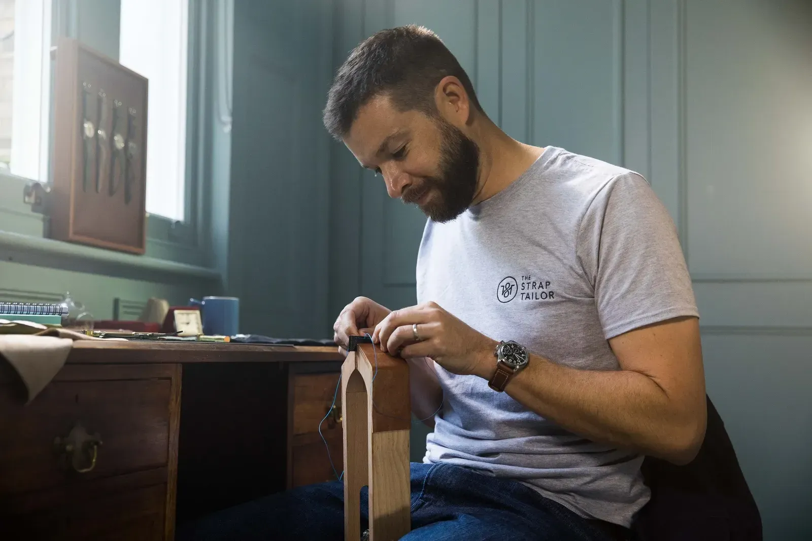 David Richards stitching a watch strap at his desk